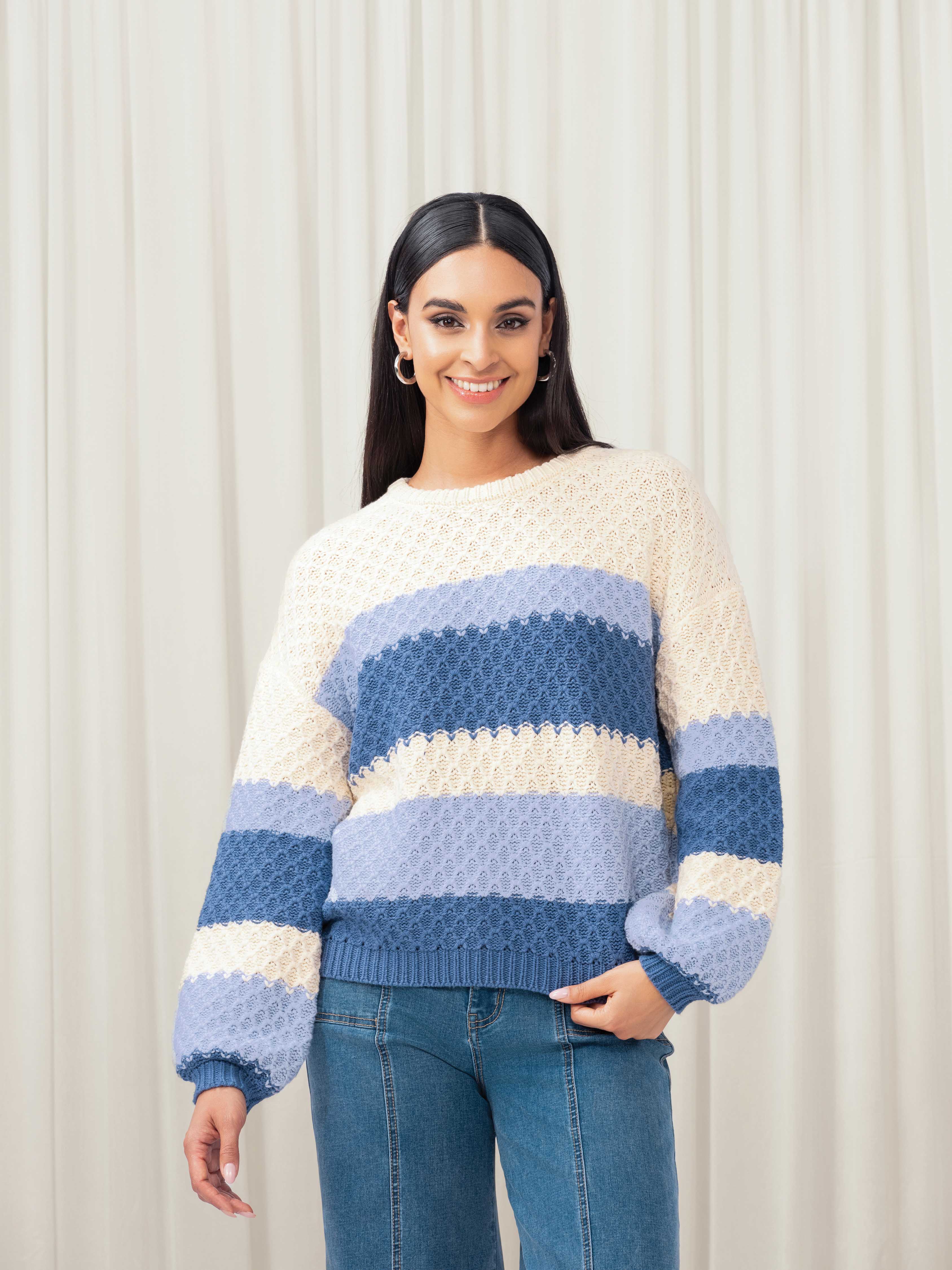 Woman wearing cream and blue sweater
