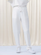 White pants worn by a person on a white background