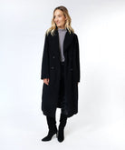 Woman wearing a black coat on a white background