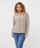 Close-up of the Aspen Button Cardigan showing its soft textured fabric, collared neckline, and decorative button-front closure.