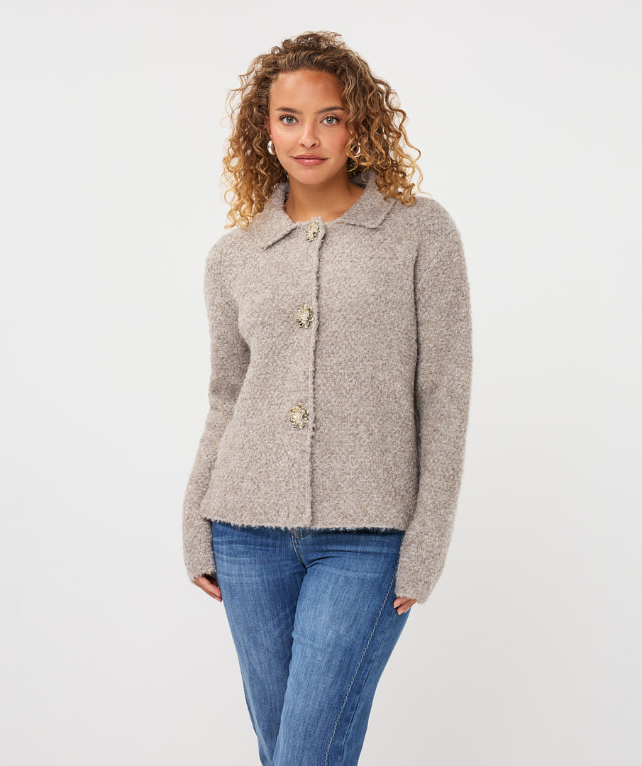 Close-up of the Aspen Button Cardigan showing its soft textured fabric, collared neckline, and decorative button-front closure.