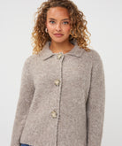 Close-up of the Aspen Button Cardigan showing its soft textured fabric, collared neckline, and decorative button-front closure.