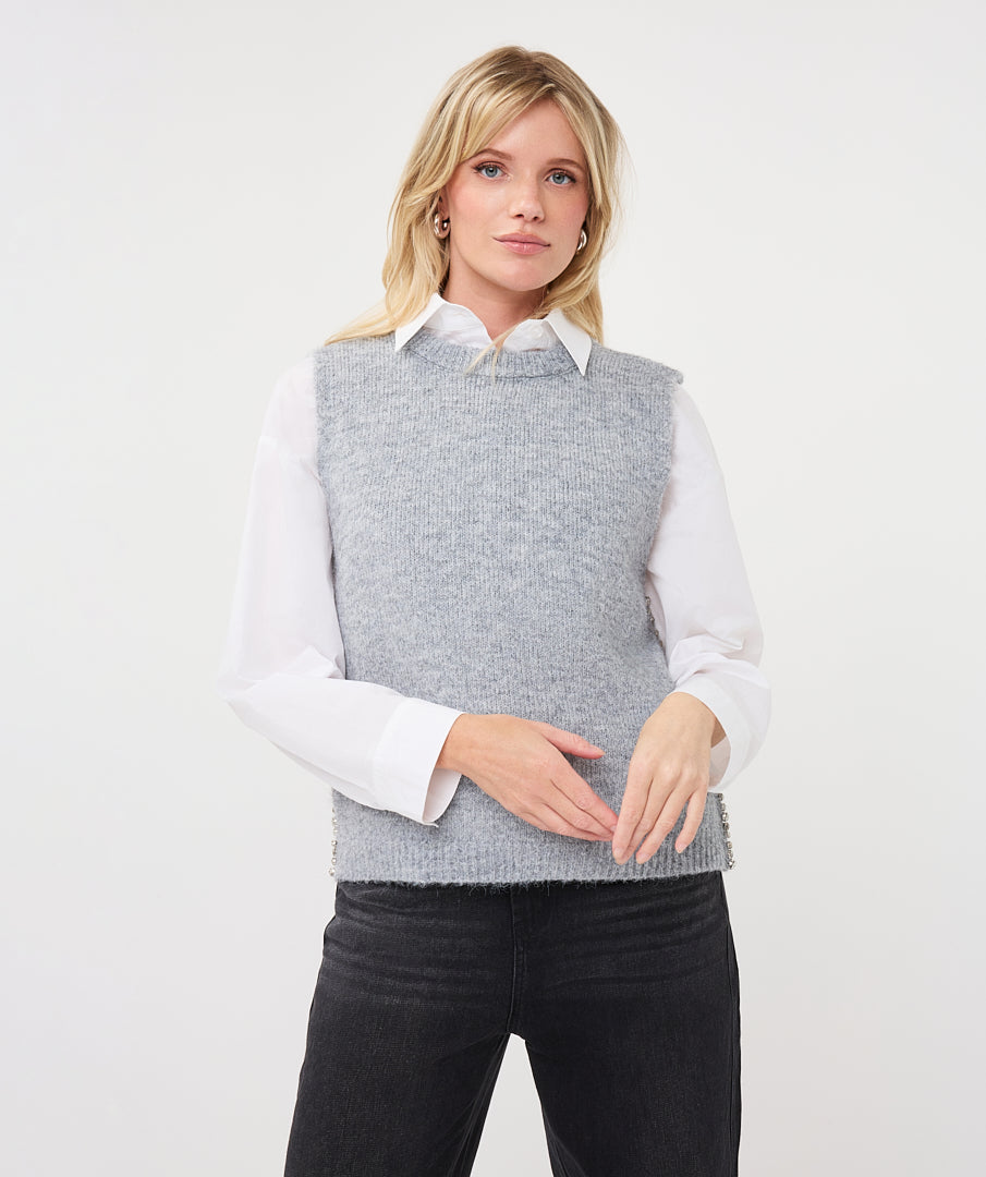 Woman wearing a textured sleeveless sweater vest layered over a collared shirt
