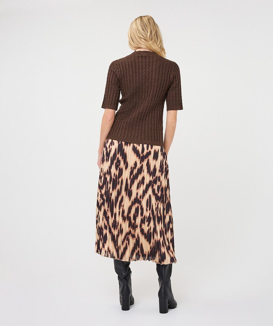 Woman modelling a brown ribbed knit short-sleeve top with a high neckline and fitted silhouette, shown from the back, paired with a printed skirt.