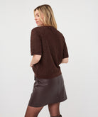 Woman wearing the brown Rosalie Lace Top with a leather-look wrap skirt
