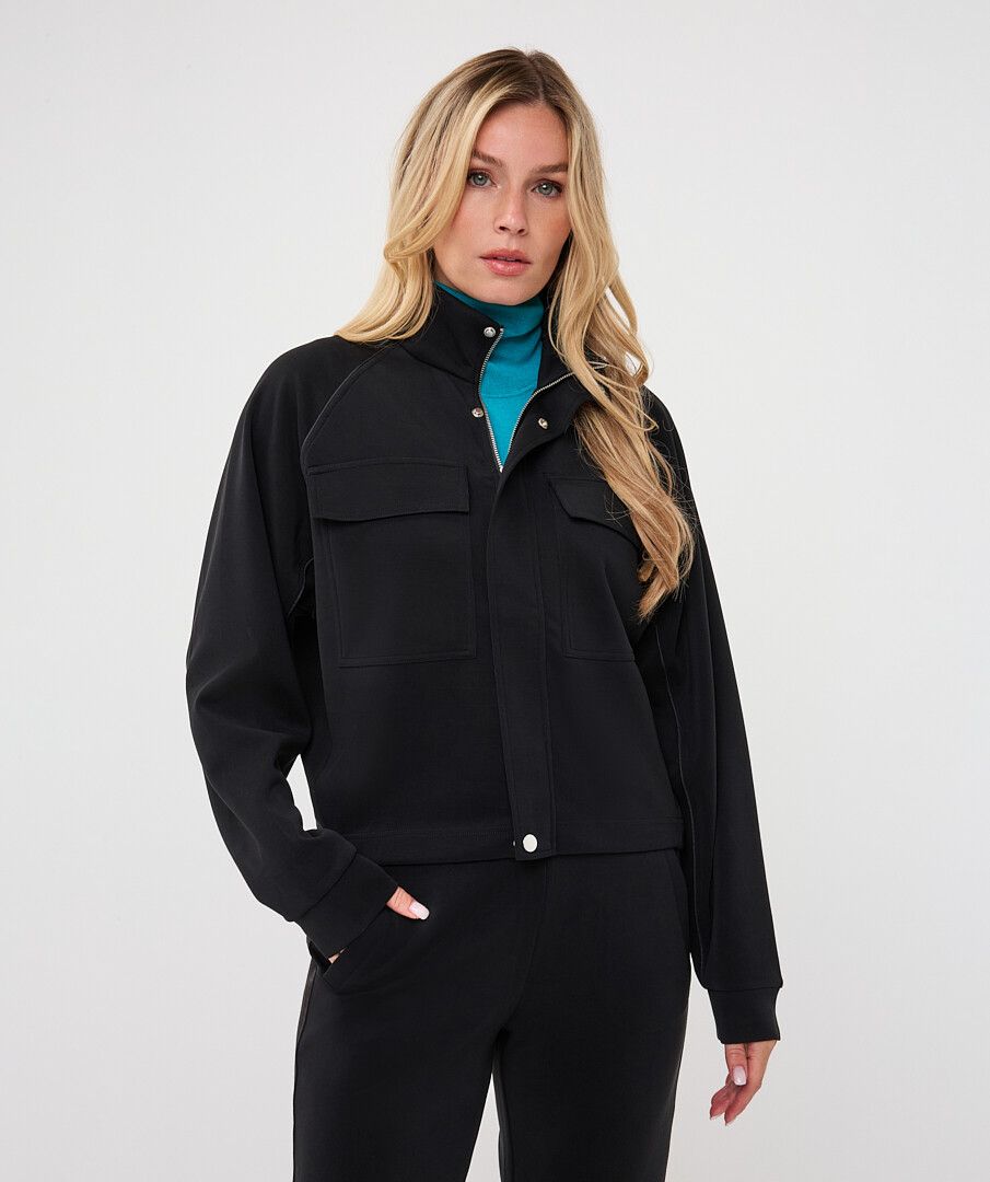 Woman wearing a black utility jacket with a stand collar and flap chest pockets