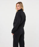 Woman wearing a black utility jacket with a stand collar and flap chest pockets 