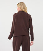 woman wearing a chocolate brown utility jacket seen from the back.
