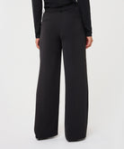 Model wearing black wide-leg trousers