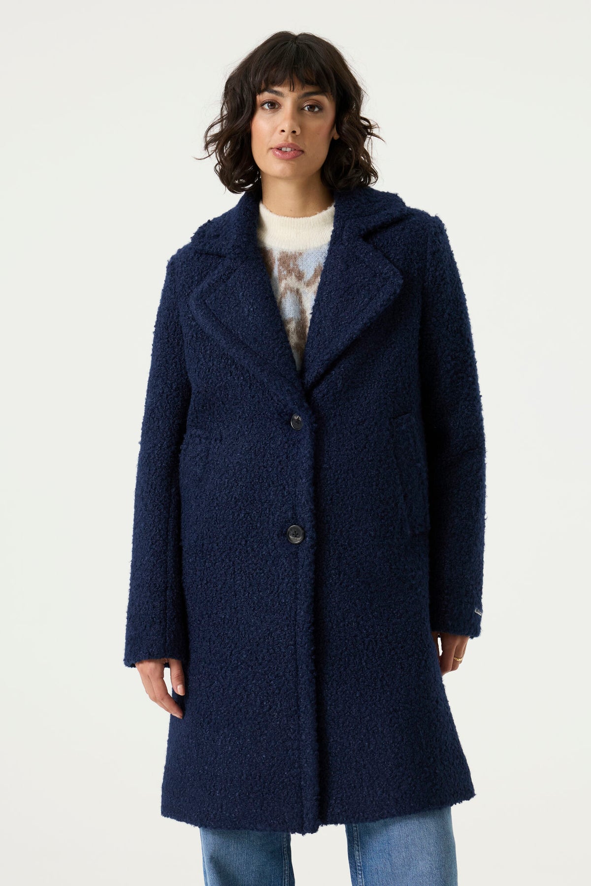 Woman wearing a navy Lennox Textured Coat with notched lapels, button front and longline silhouette.