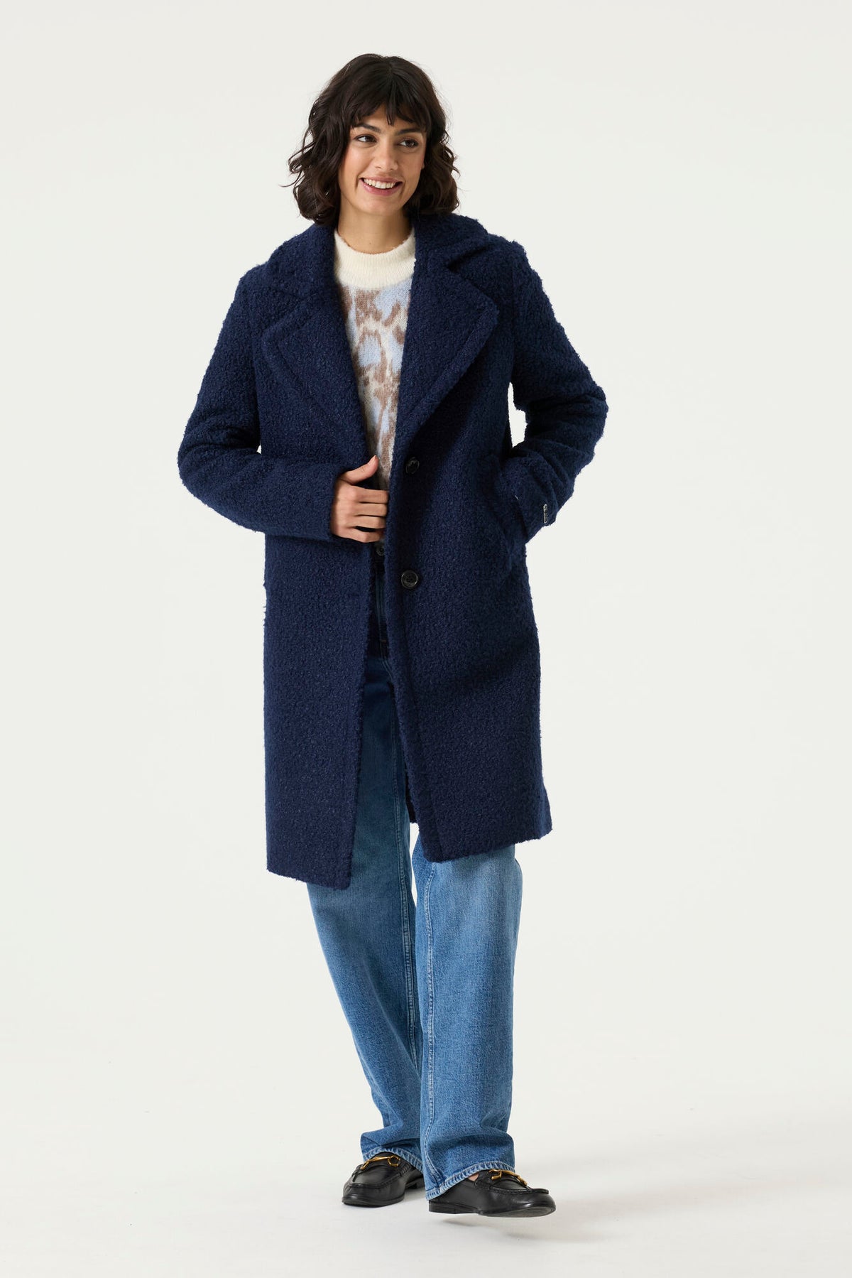 Woman wearing a navy Lennox Textured Coat with notched lapels, button front and longline silhouette.