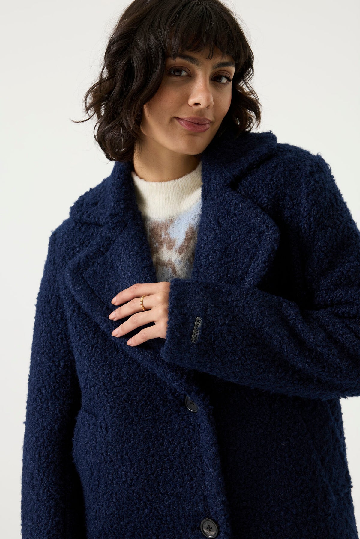 Woman wearing a navy Lennox Textured Coat with notched lapels, button front and longline silhouette.