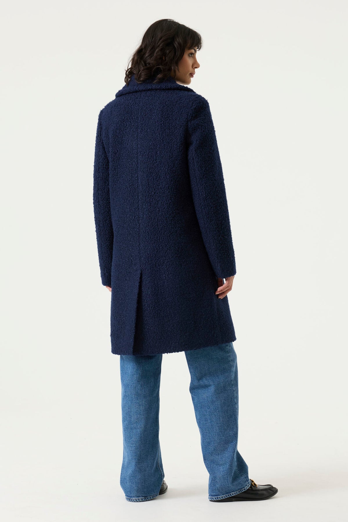 Woman wearing a navy Lennox Textured Coat with notched lapels, button front and longline silhouette.