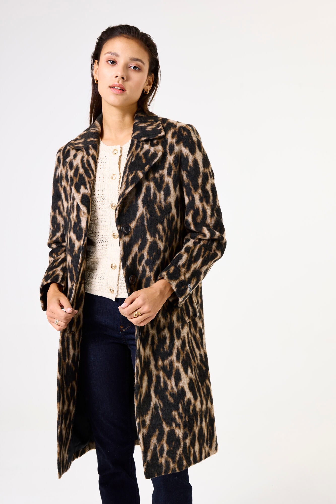 Woman wearing a leopard print coat on a white background