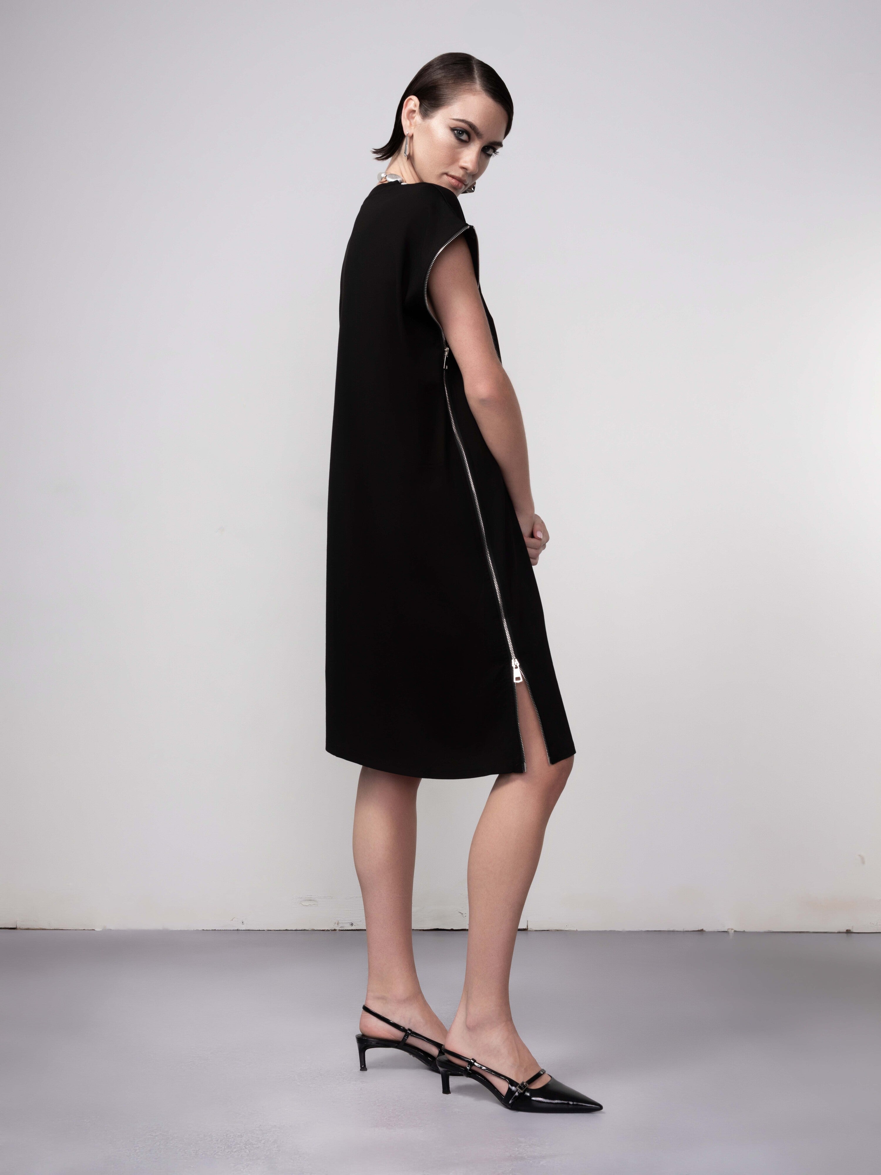 Back and side view of black tunic dress featuring side zip and relaxed silhouette