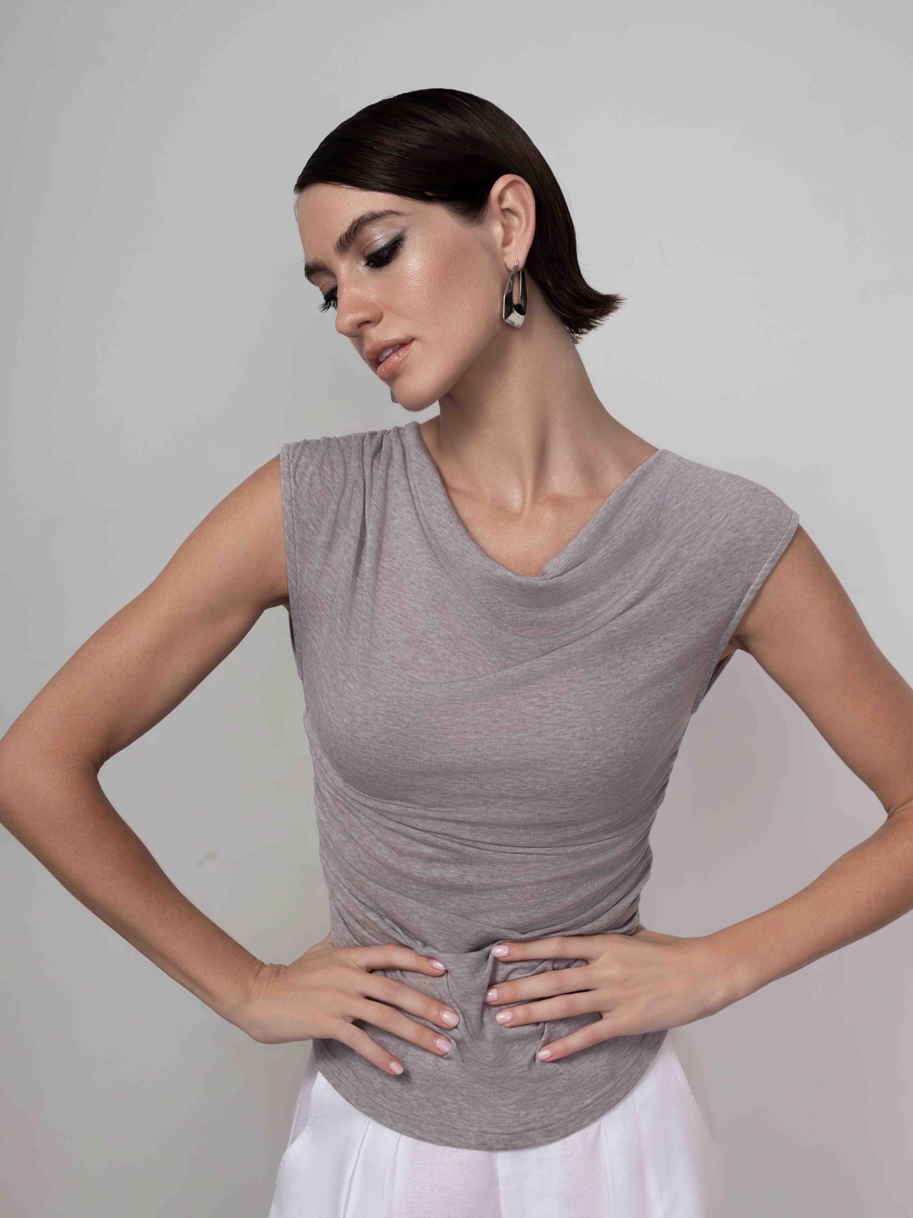 Sleeveless drape neck pullover in a soft knit fabric, featuring a relaxed, body-skimming fit with subtle stretch, styled with a fluid cowl neckline for an elegant, modern look.