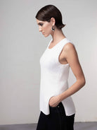 woman wearing a white sleeveless knit shell top with wide-leg dark jeans