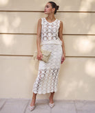 Model wearing a cream crochet midi skirt with matching sleeveless crochet top, styled with neutral accessories for an elevated summer look.