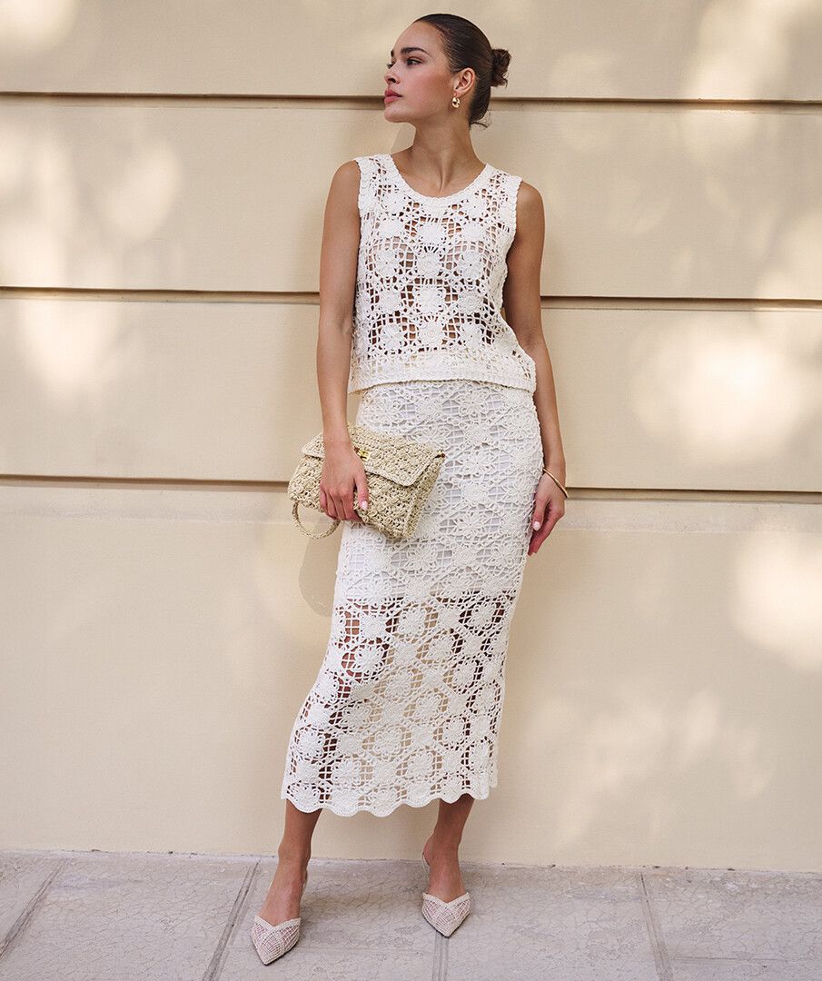 Model wearing a cream crochet midi skirt with matching sleeveless crochet top, styled with neutral accessories for an elevated summer look.