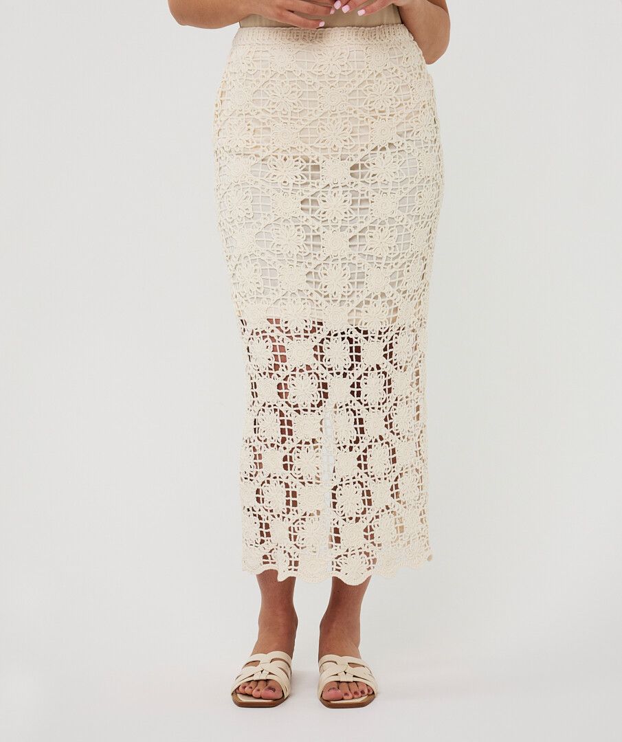 Front view of a cream crochet midi skirt featuring detailed lace-like texture, fitted silhouette, and scalloped hemline.