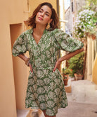 green printed tie-waist day dress on a model, featuring a relaxed fit, three-quarter sleeves, and a gently flared skirt