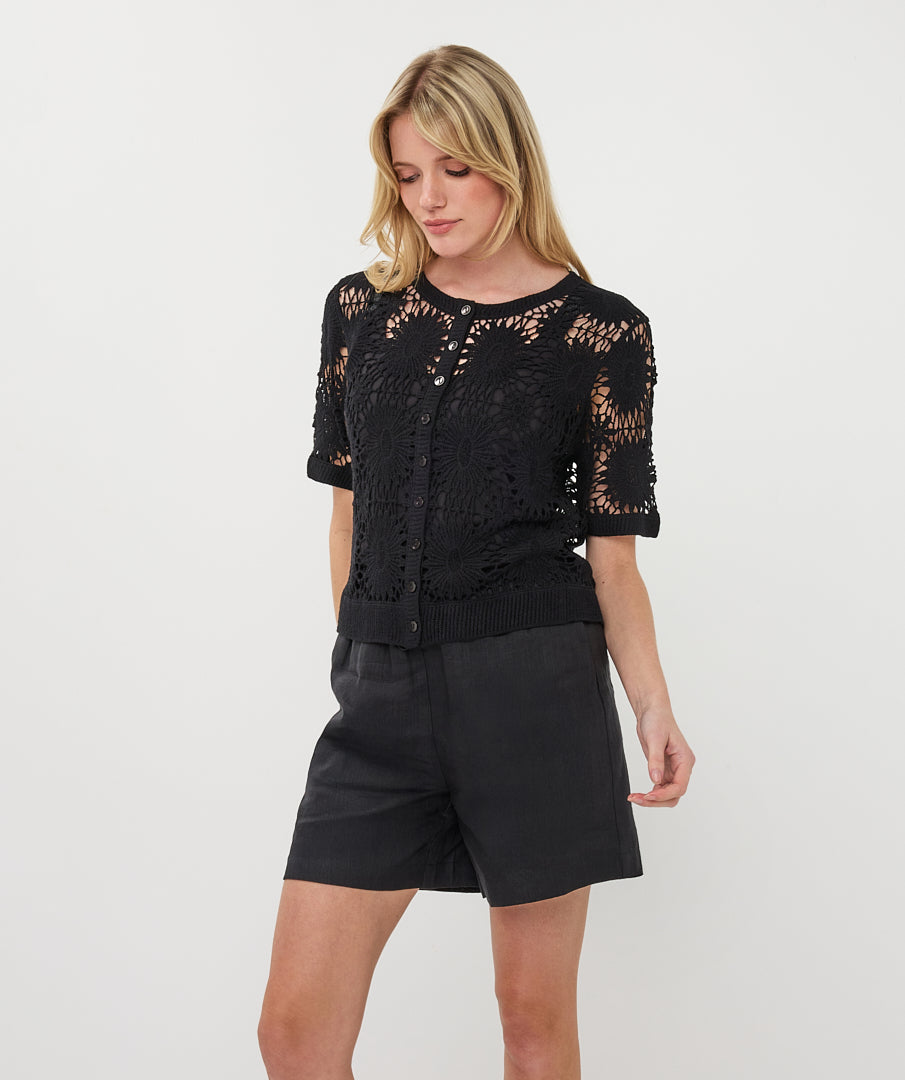 black short sleeve crochet cardigan with button-up closure and intricate open-stitch design, styled with matching shorts