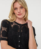 black short sleeve crochet cardigan with button-up closure and intricate open-stitch design