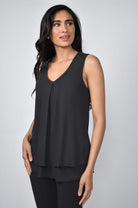 Woman wearing a black sleeveless top against a gray background