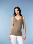 Woman wearing taupe sleeveless tank top with white pants.