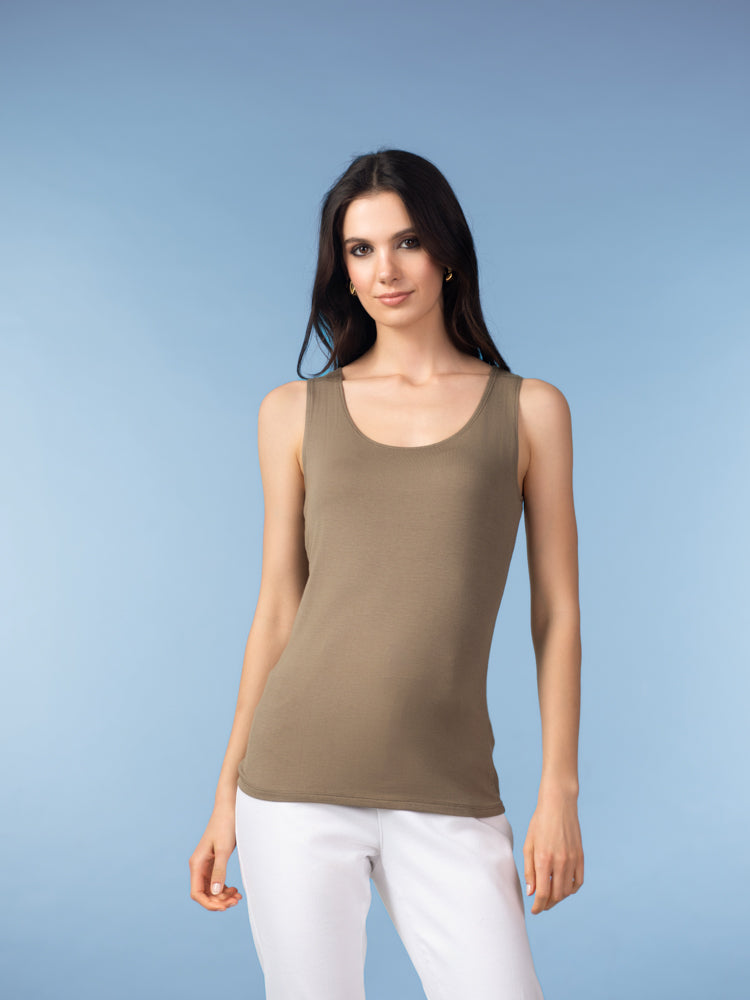 Woman wearing taupe sleeveless tank top with white pants.