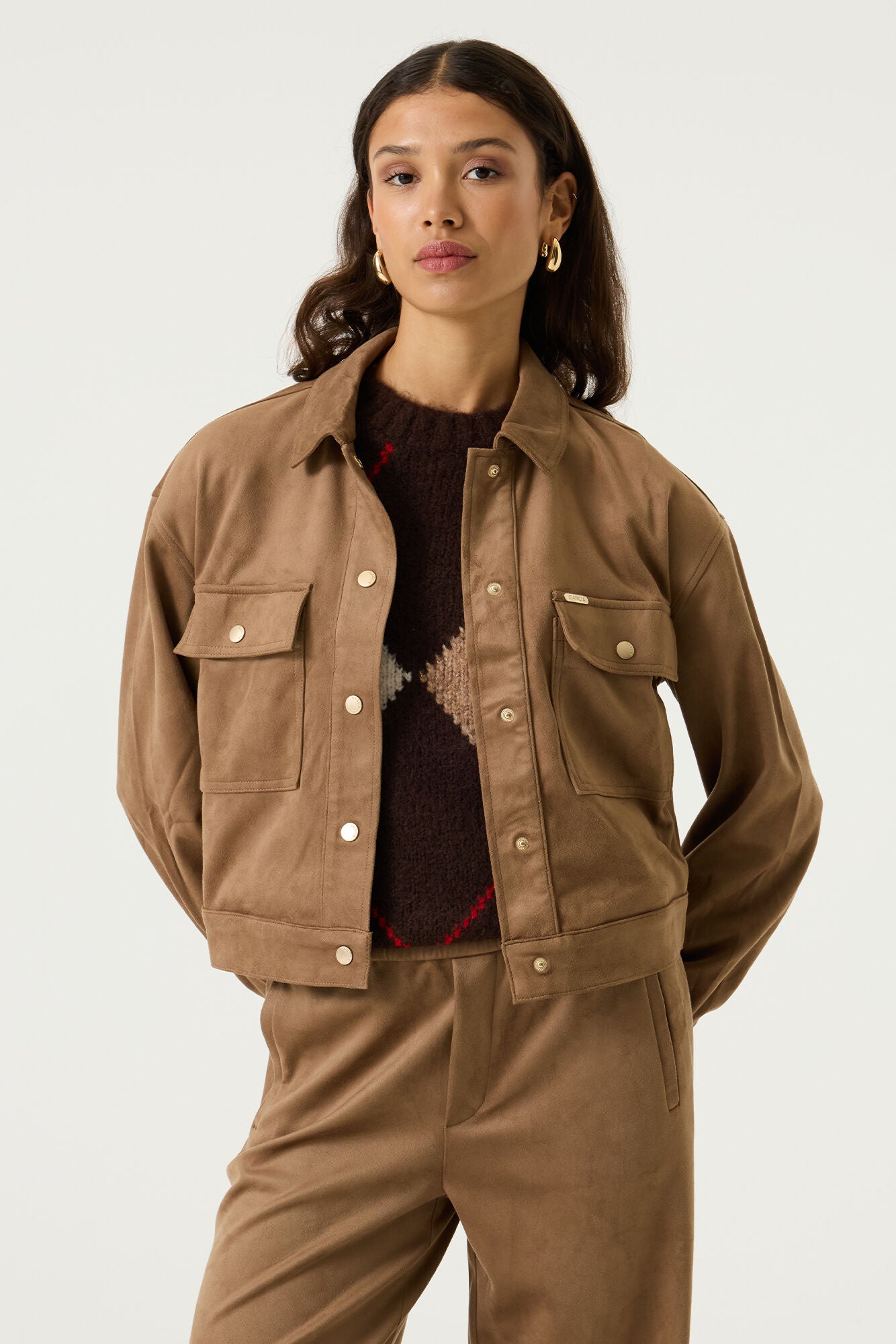 Woman wearing the Aspen cropped utility jacket in brown with snap-button closure, flap chest pockets and long sleeves.