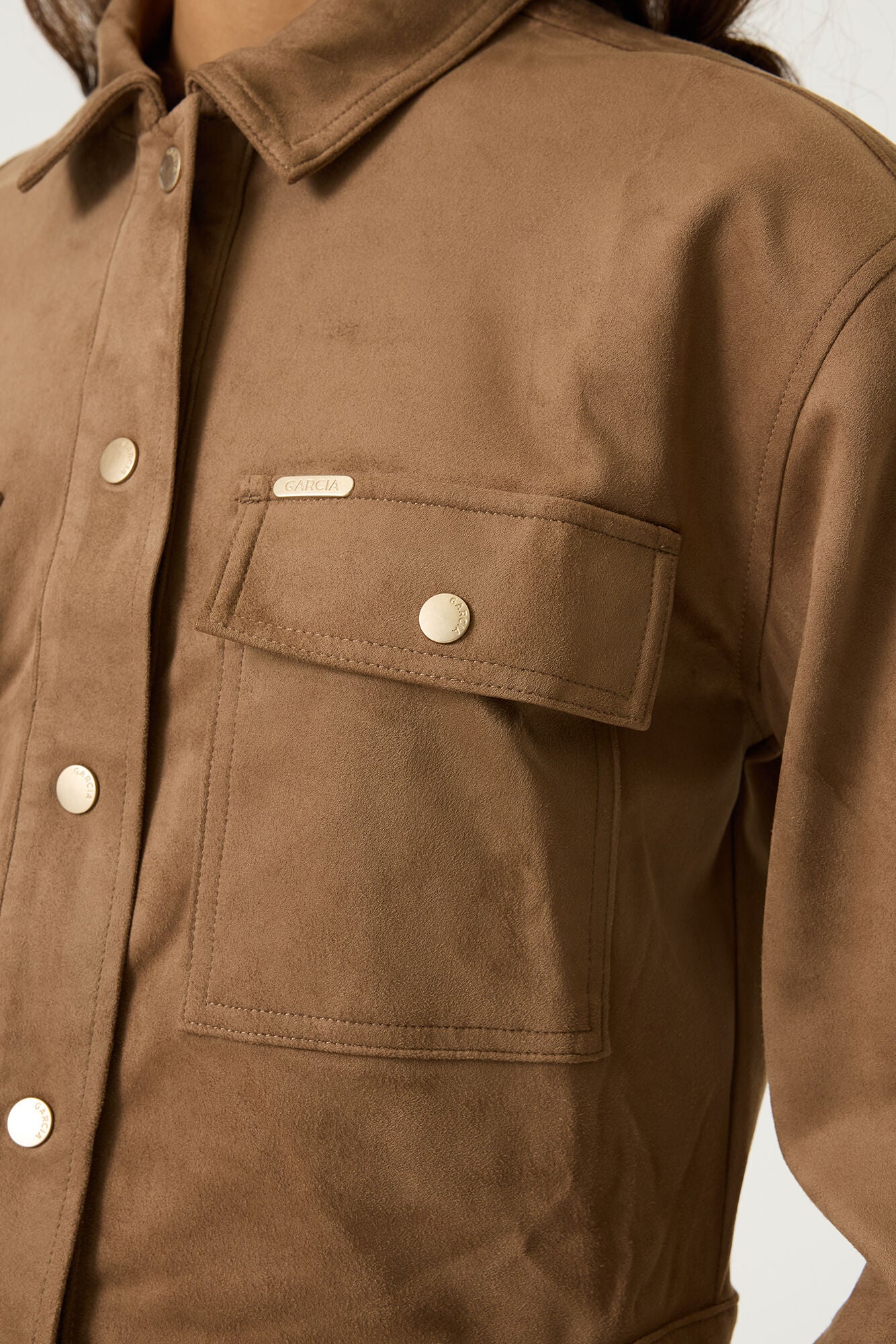 Close-up of the brown Aspen cropped utility jacket showing the collared neckline, snap-button closure and flap chest pocket.