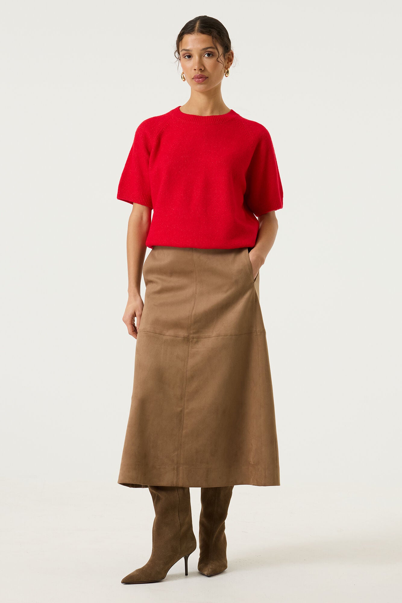 Woman wearing a brown Rosalie seamed midi skirt with a red short-sleeve knit top and black knee-high boots, shown in a full-length studio view.