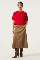 Woman wearing a brown Rosalie seamed midi skirt with a red short-sleeve knit top and black knee-high boots, shown in a full-length studio view.