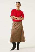 Woman wearing a brown Rosalie seamed midi skirt with a red short-sleeve knit top and black knee-high boots, shown in a full-length studio view.