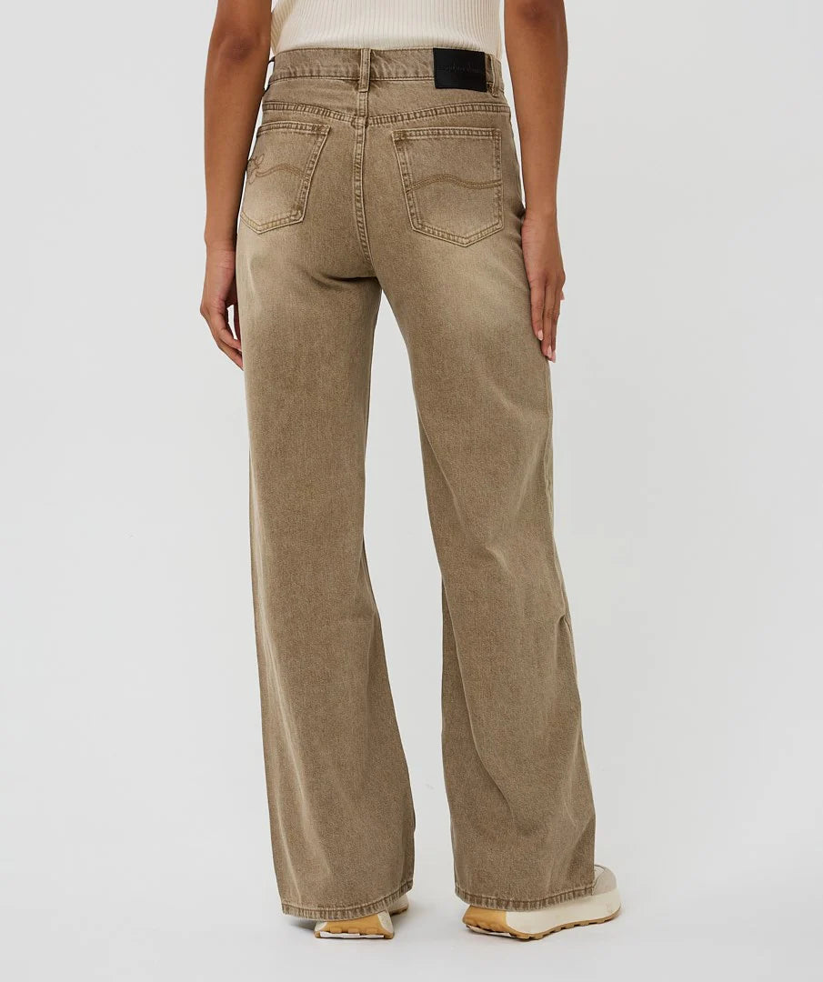 Person wearing beige wide-leg jeans on a plain background