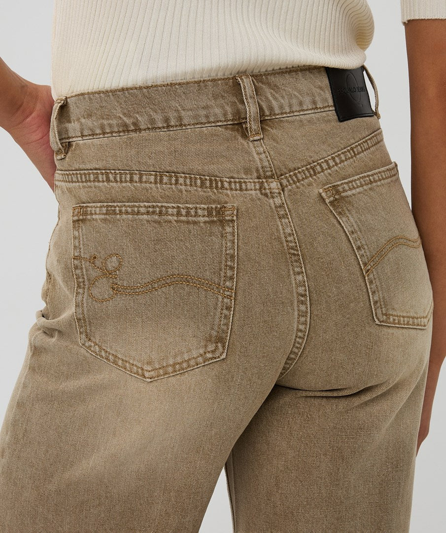 Brown jeans worn by a person on a plain background