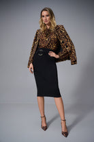 woman standing in a leopard top and black pencil skirt
