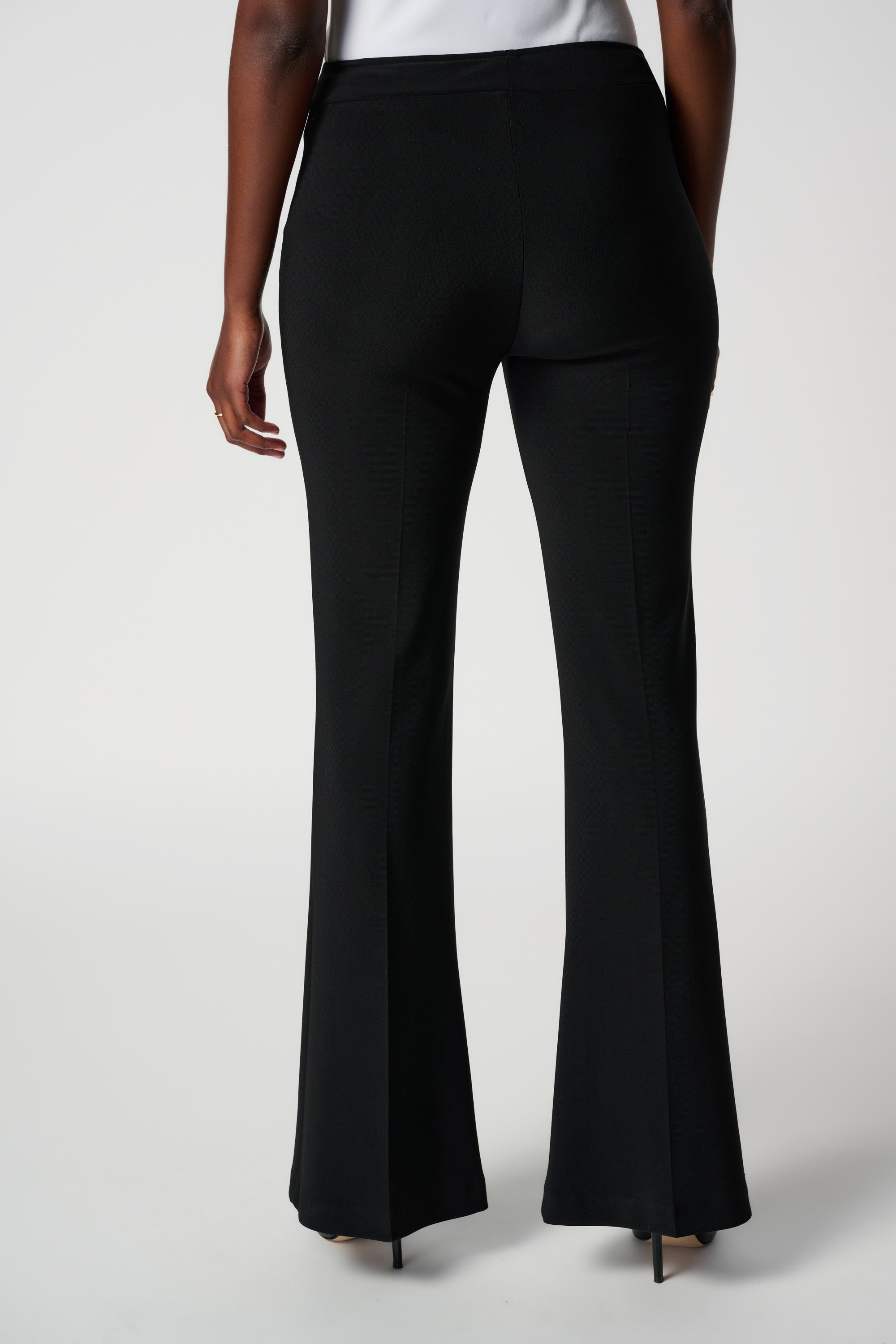 The back of black flare pants on model