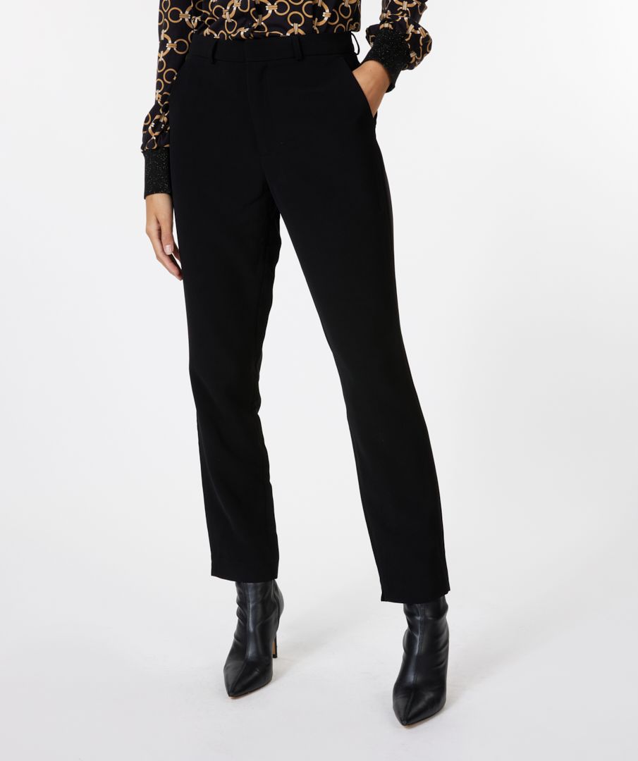 Person wearing black pants and black boots on a white background