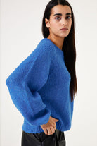 Person wearing a blue sweater against a white background